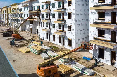 heavy machinery installing facing to a building under construction