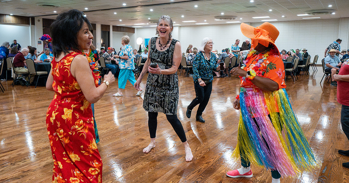Group of older women smiling and dancing at the 2025 Senior Dance.