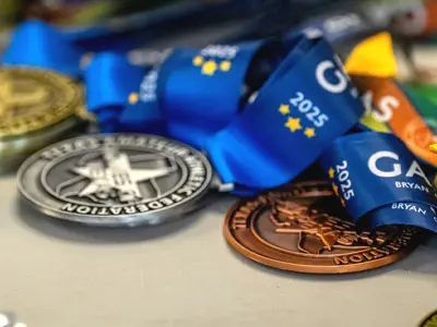gold, silver and bronze winner's medals for the 2025 Games of Texas laid out on a table