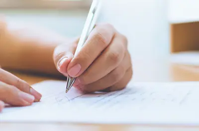 hands filling out a form writing with a pen