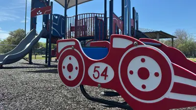 Close-up of race car spring rider at Ibarra Park playground.
