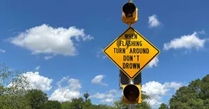 flashing roadway sign with text that says "When Flashing, Turn Around, Don't Drown"