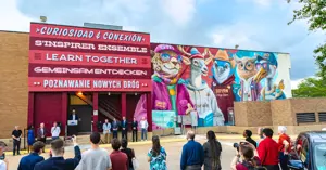 crowd of people viewing the unveiling of the Sister Cities mural on the side of Mounce Public Library 