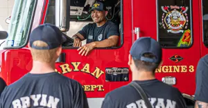 Bryan fireman sitting in the driver's seat of the new fire truck smiling