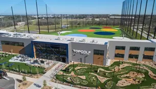 Aerial view of the TopGolf facility with minigolf course and colorful hitting range.
