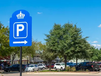 View of Main Street in Downtown Bryan with cars parked behind a "Parking" street sign