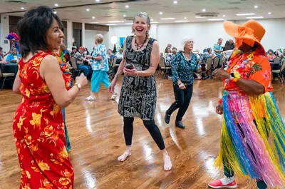 Four women dancing and having fun at a tropical-themed Senior Dance.