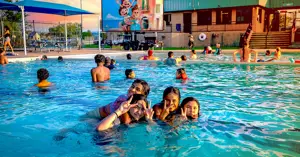 families having fun at the pool with a projected movie on a large screen in the background