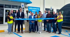 Bryan leadership and Amazon staff standing to witness the ribbon cutting of the new Amazon delivery station facility