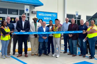 Bryan leadership and Amazon staff standing to witness the ribbon cutting of the new Amazon delivery station facility