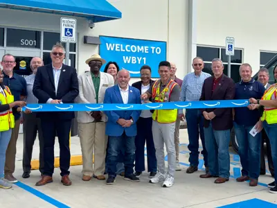 Bryan leadership and Amazon staff standing to witness the ribbon cutting of the new Amazon delivery station facility