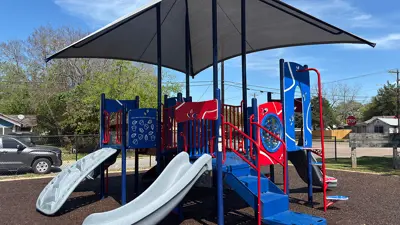 Ages 2-5 playground at Ibarra Park, showing slides and an integrated shade canopy.