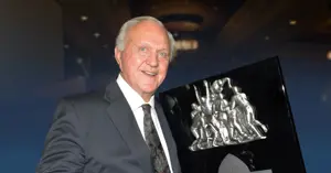 Jackie Sherrill holding a plaque.