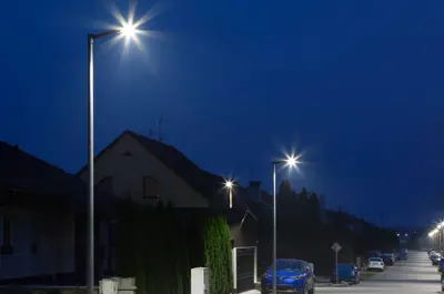street lights illuminating the road in a neighborhood at night