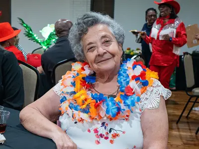 Woman wearing a lei and smiling.