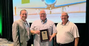 Brandon Reid receiving the 2025 Airport Professional of the Year award at the Texas Aviation Conference, standing between Kevin Russell and Joseph Dunn.