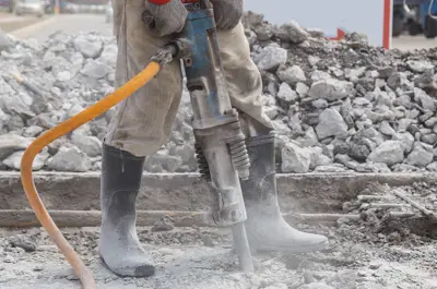 construction worker jackhammering concrete
