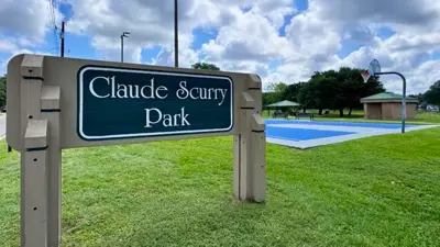 Claude Scurry Park sign with park in the background