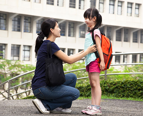photo of mother adjusting child's backpack