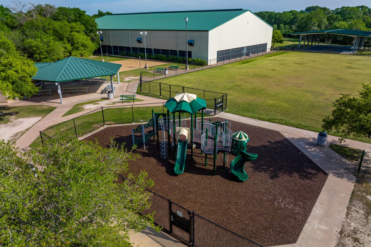 Photo of Austin Colony Park with playground and courts in view.