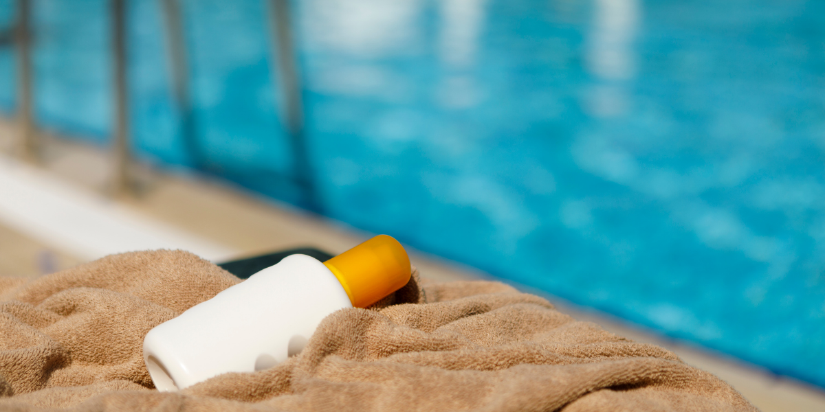 Photo of a bottle of sunscreen next to a pool