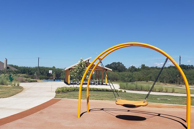 Swing, pavilion and basketball courts at a park