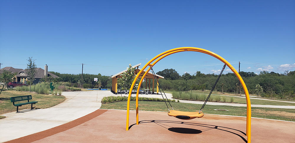 Swing, pavilion and basketball courts at a park