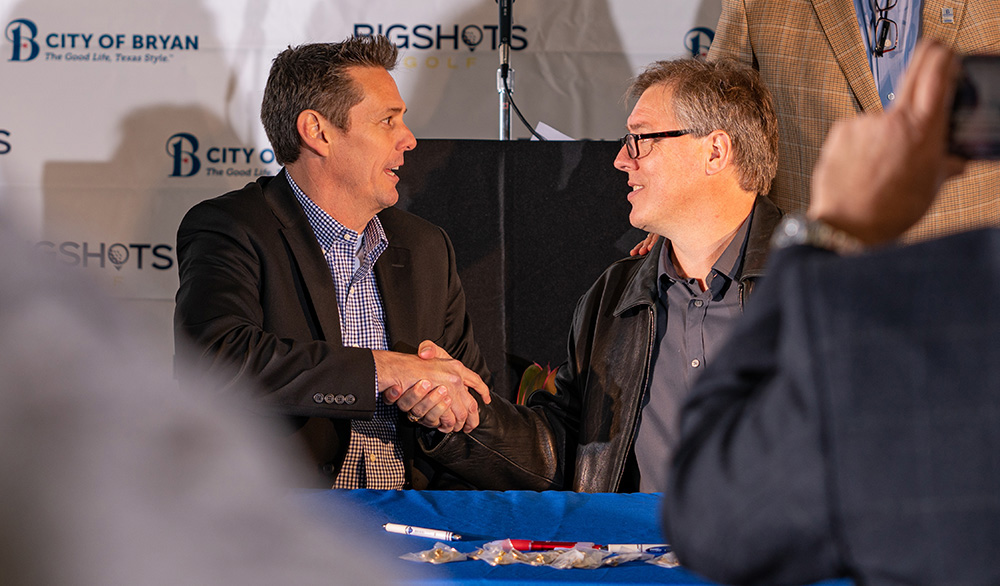 BigShots CEO Tony Wehner and Bryan Mayor Andrew Nelson shake hands after the signing ceremony.