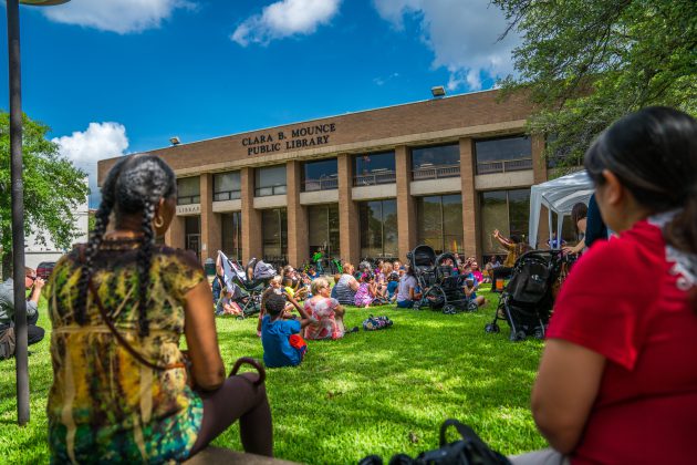 People gather outside on the lawn of Mounce Library to hear a storyteller.