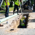 Wastewater workers installing a new sewer pipe.