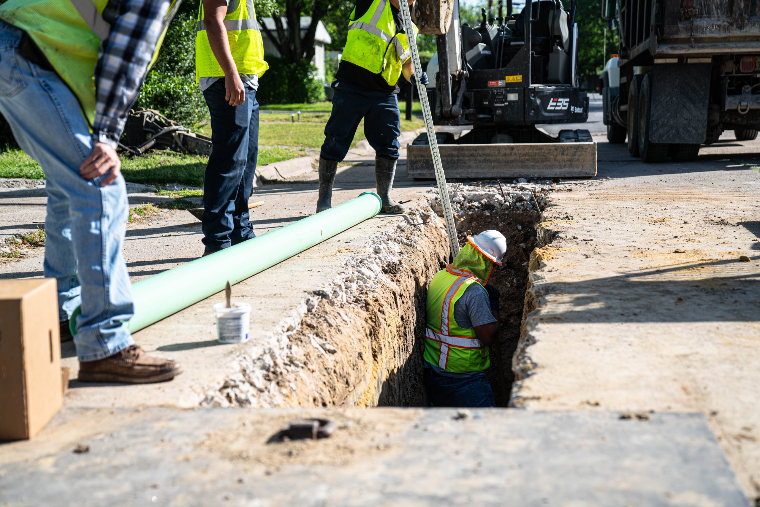 Wastewater workers installing a new sewer pipe.