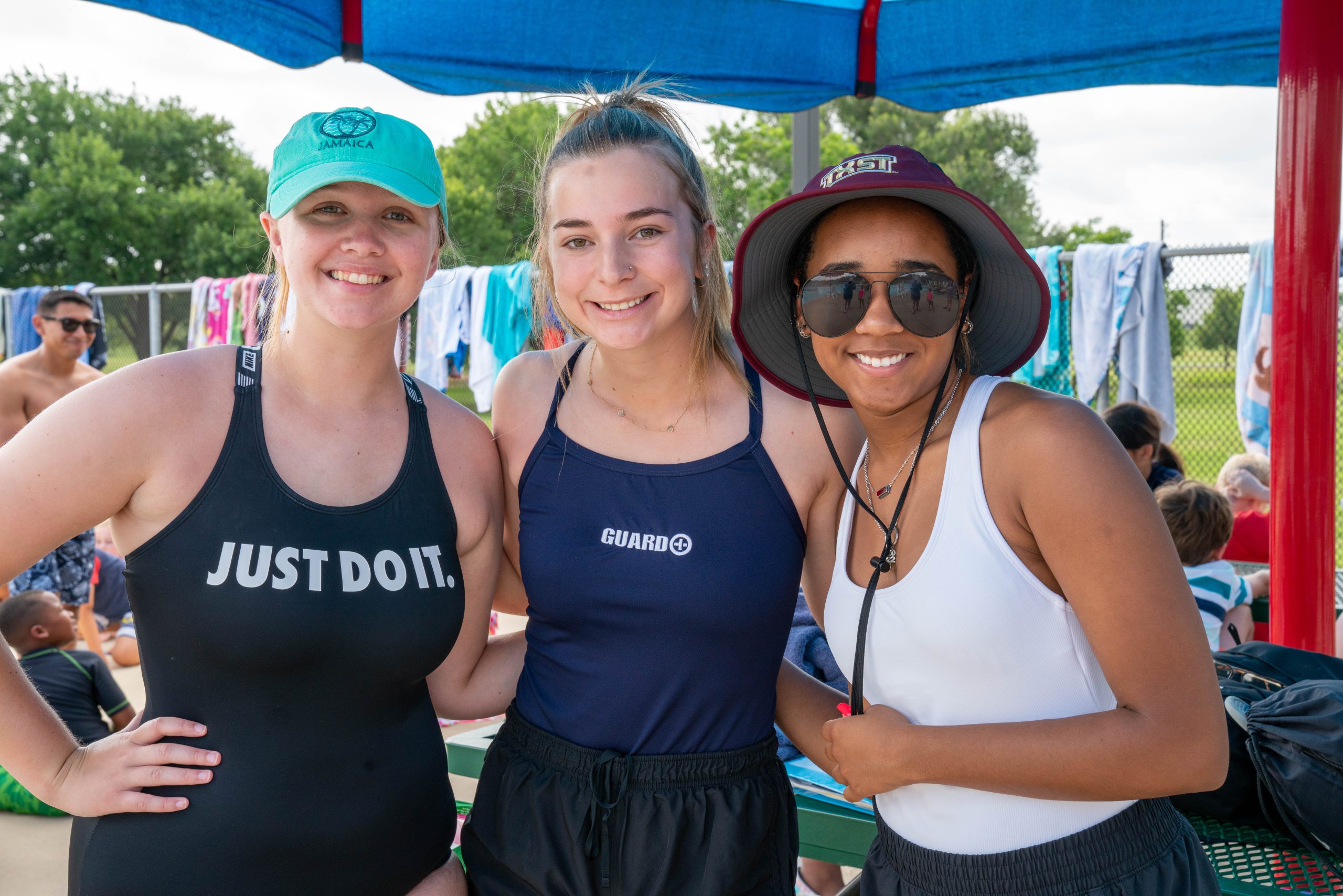 Three girls smiling at the pool.