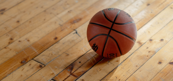 Photo of a basketball on the floor of a gym
