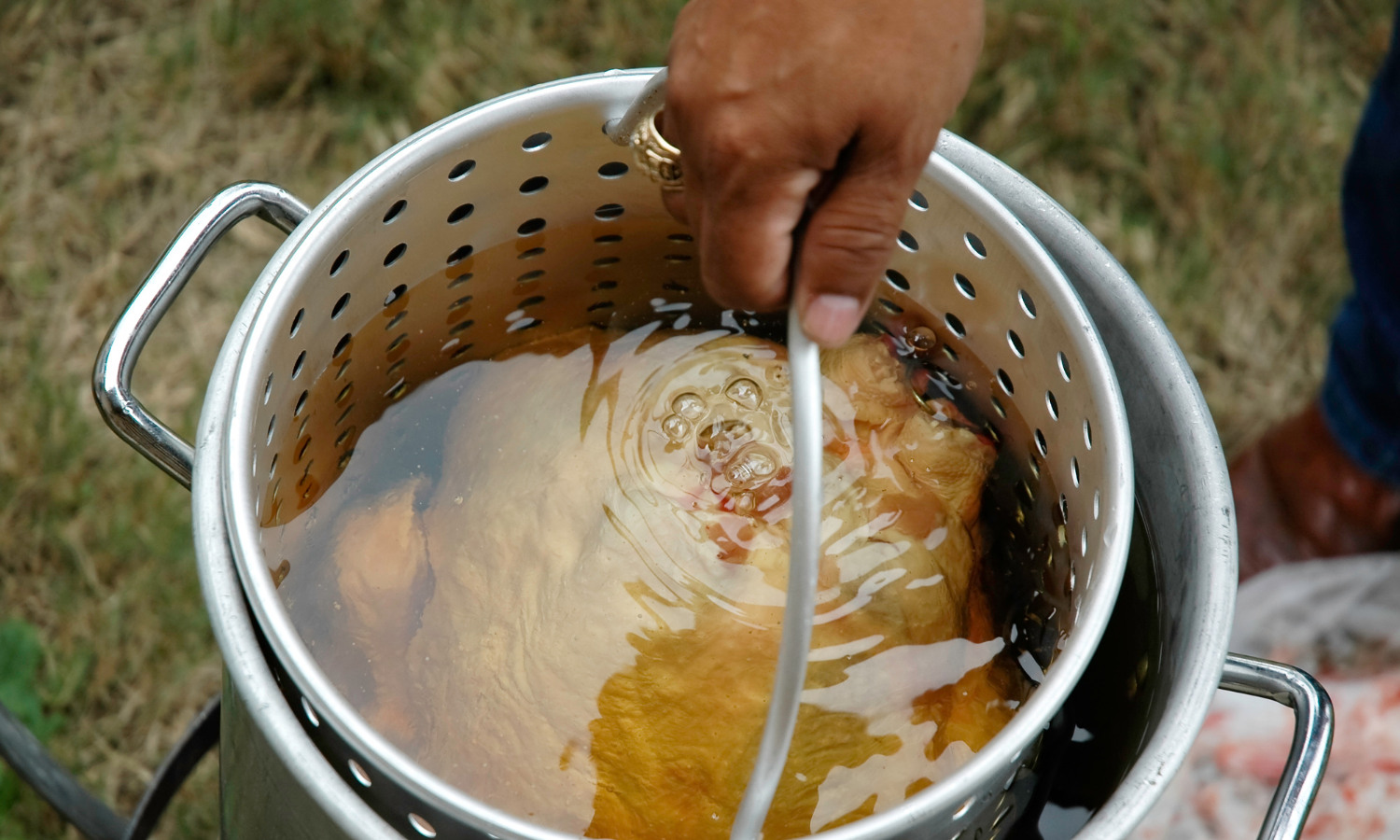 A person deep frying a turkey.