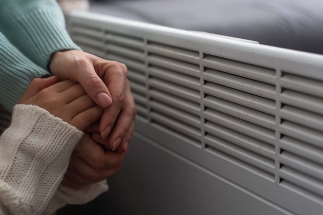 warming hands by a heater
