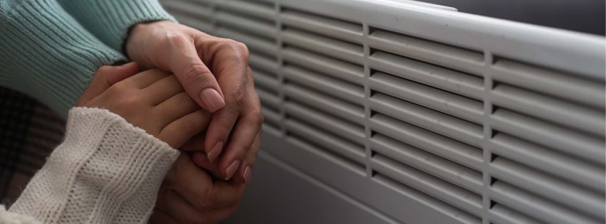 warming hands by a heater