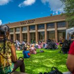 Photo of families gathered to listen to anAfrican storyteller on the lawn of Mounce Library.