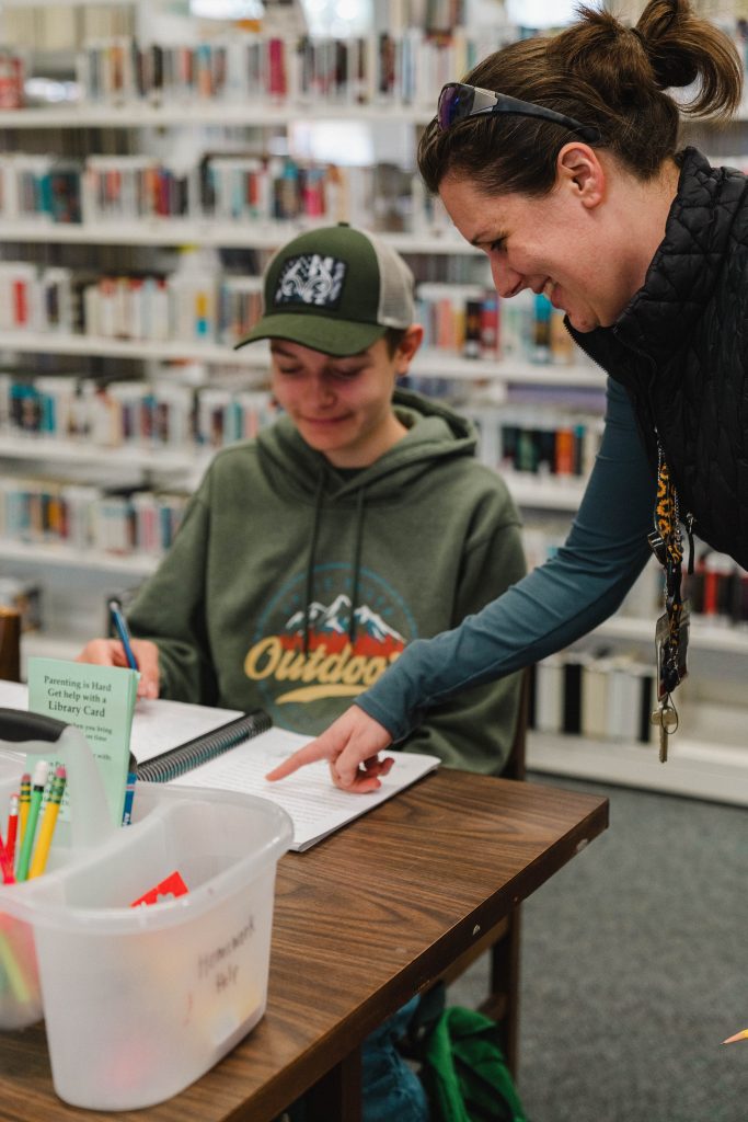 Photo of librarian helping with homework. 