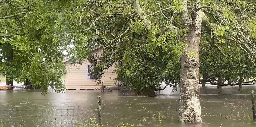 Flooding waters around a house and yard.