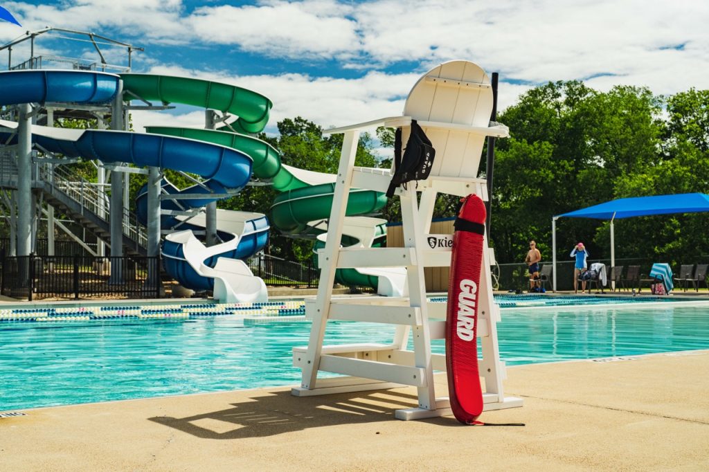Photo of a lifeguard stand with a tube and fanny pack that say guard on them at the Bryan Aquatic Center. 