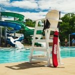 Photo of a lifeguard stand with a tube and fanny pack that say guard on them at the Bryan Aquatic Center.