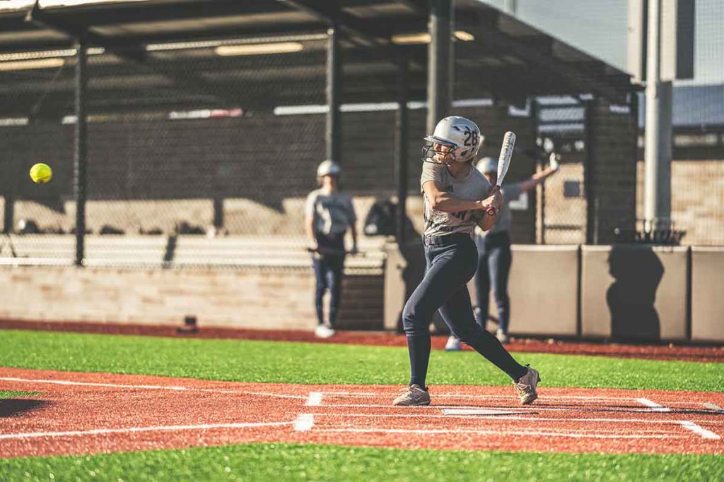 Softball player hitting a ball during a softball tournament in Bryan.