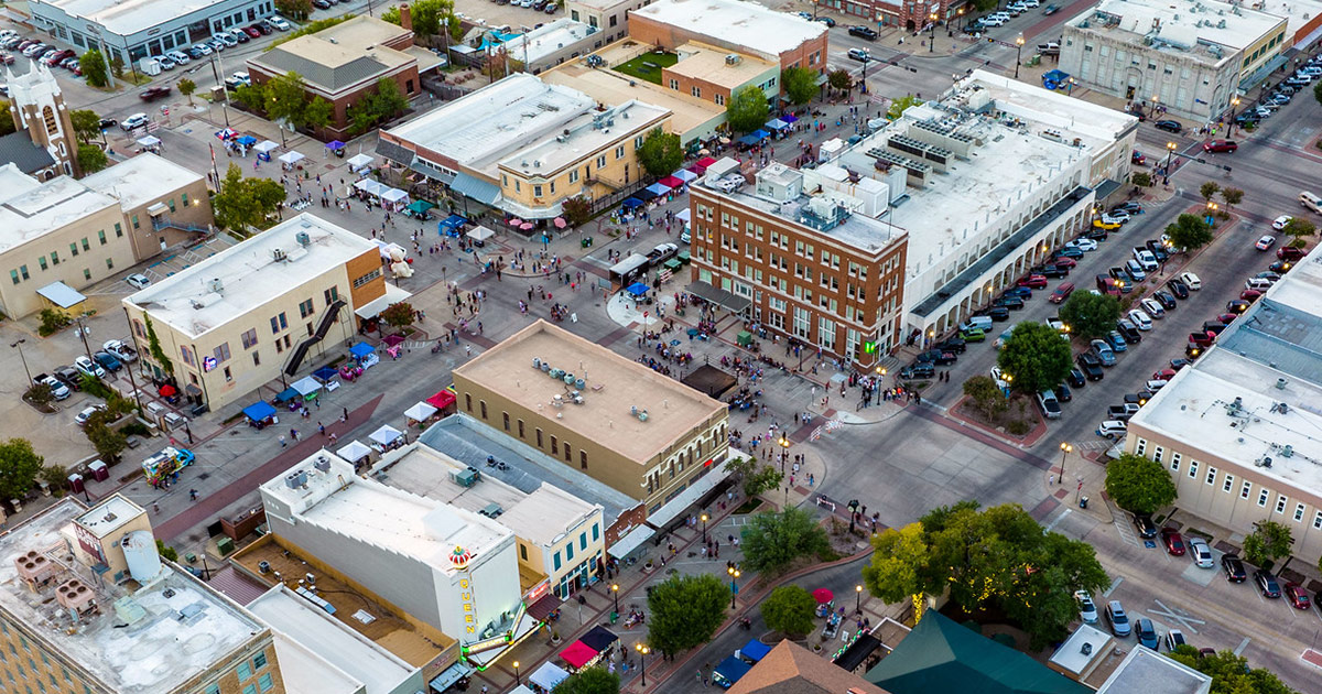 aerial image of downtown Bryan during an event with many pedestrians and parked vehicles