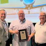 Brandon Reid receiving the 2025 Airport Professional of the Year award at the Texas Aviation Conference, standing between Kevin Russell and Joseph Dunn