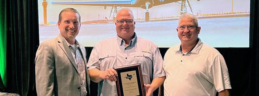 Brandon Reid receiving the 2025 Airport Professional of the Year award at the Texas Aviation Conference, standing between Kevin Russell and Joseph Dunn