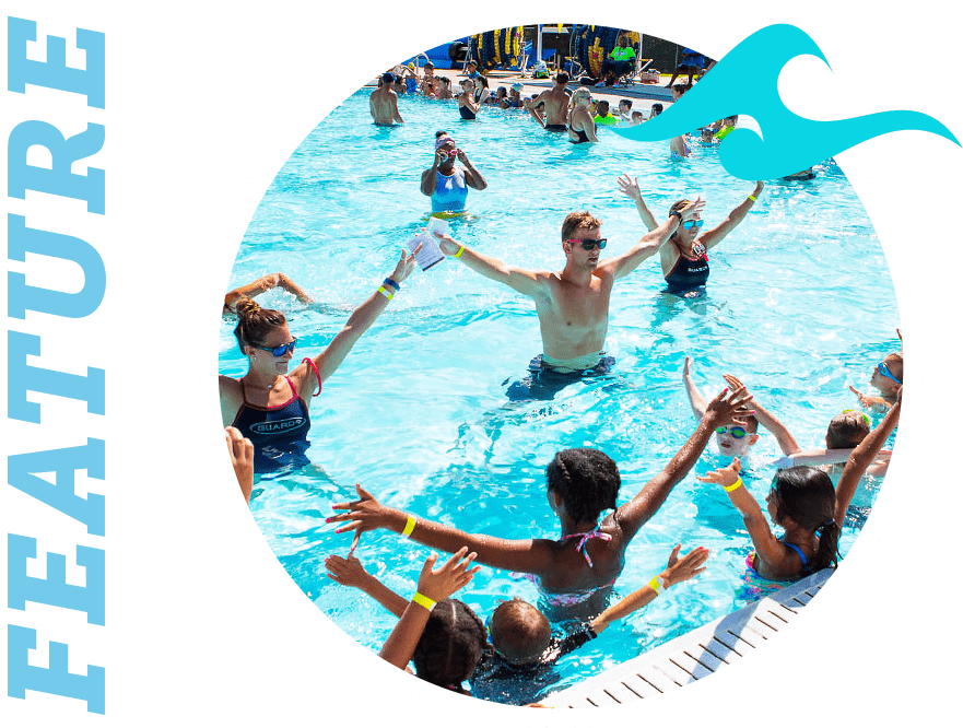 group of children in a pool participating in a swim lesson activity