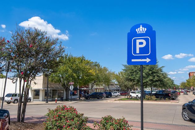 view down Main Street filled with parked vehicles behind a blue Bryan parking sign